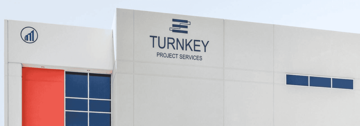 A modern white building with the sign TURNKEY PROJECT SERVICES and a blue logo above it; a smaller blue-and-white circular logo appears to the left on a separate section of the building.